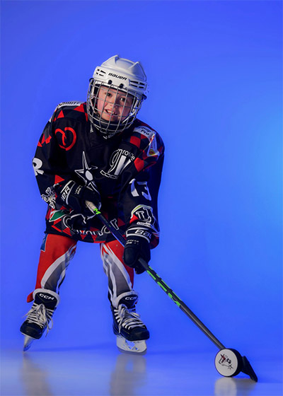 Enfant jouant au hockey sur glace lors d'une séance photo passion au studio Claire Bollinger